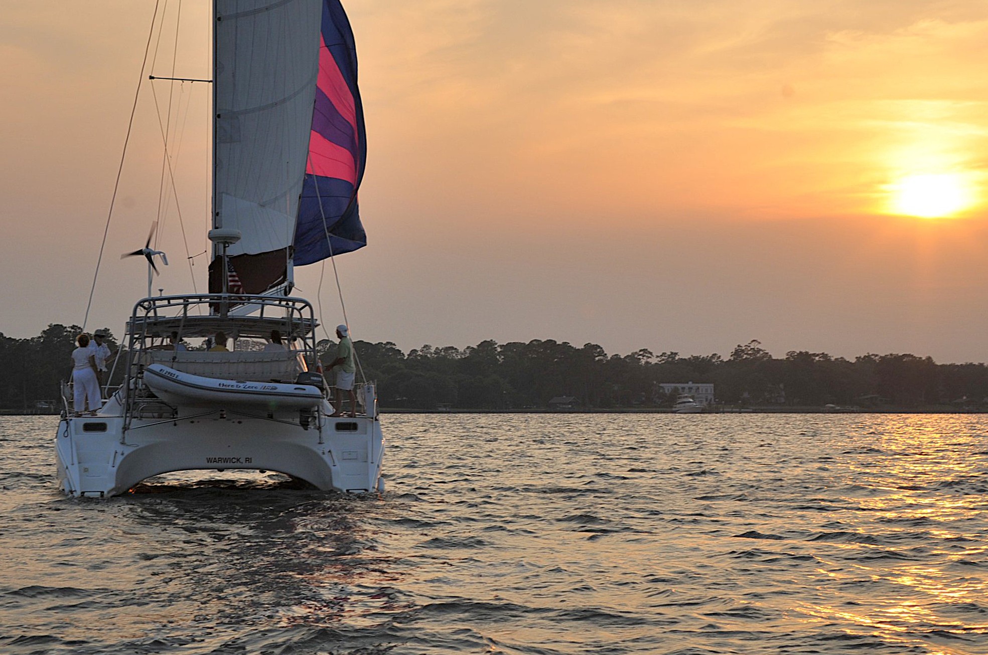 Now and Zen catamaran sailing on the St. John's River at sunset